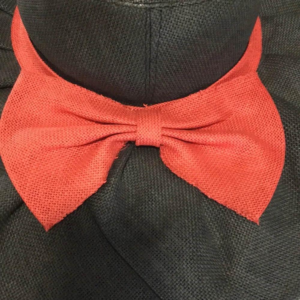 Woman’s black wide brim floppy burlap type hat with red bow.